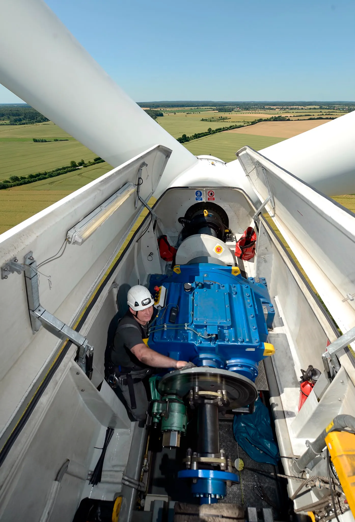 Techniker arbeitet am Getriebe in der geöffneten Gondel einer Windkraftanlage