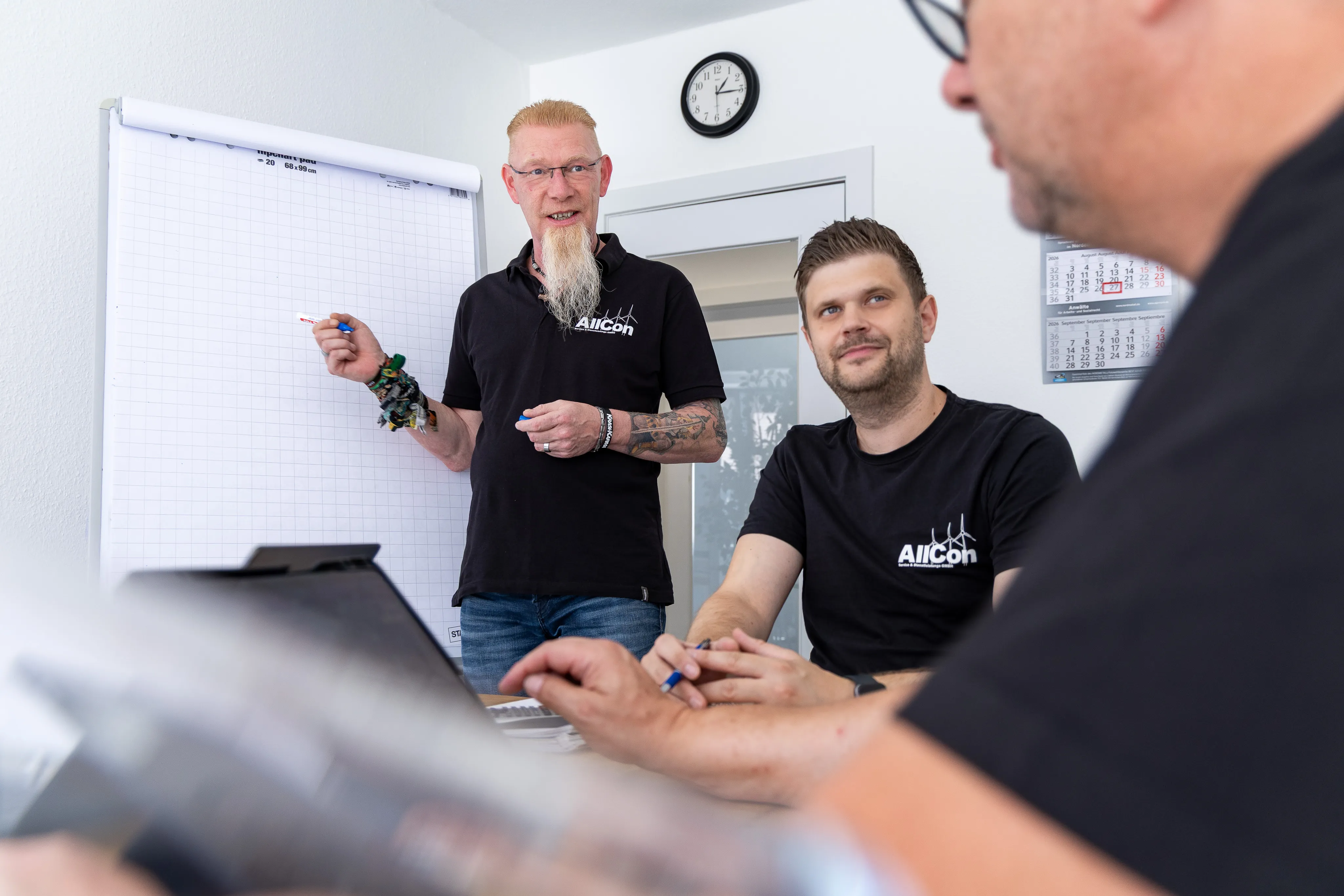 Kollege erläutert am Flipchart im Büro Hamburg